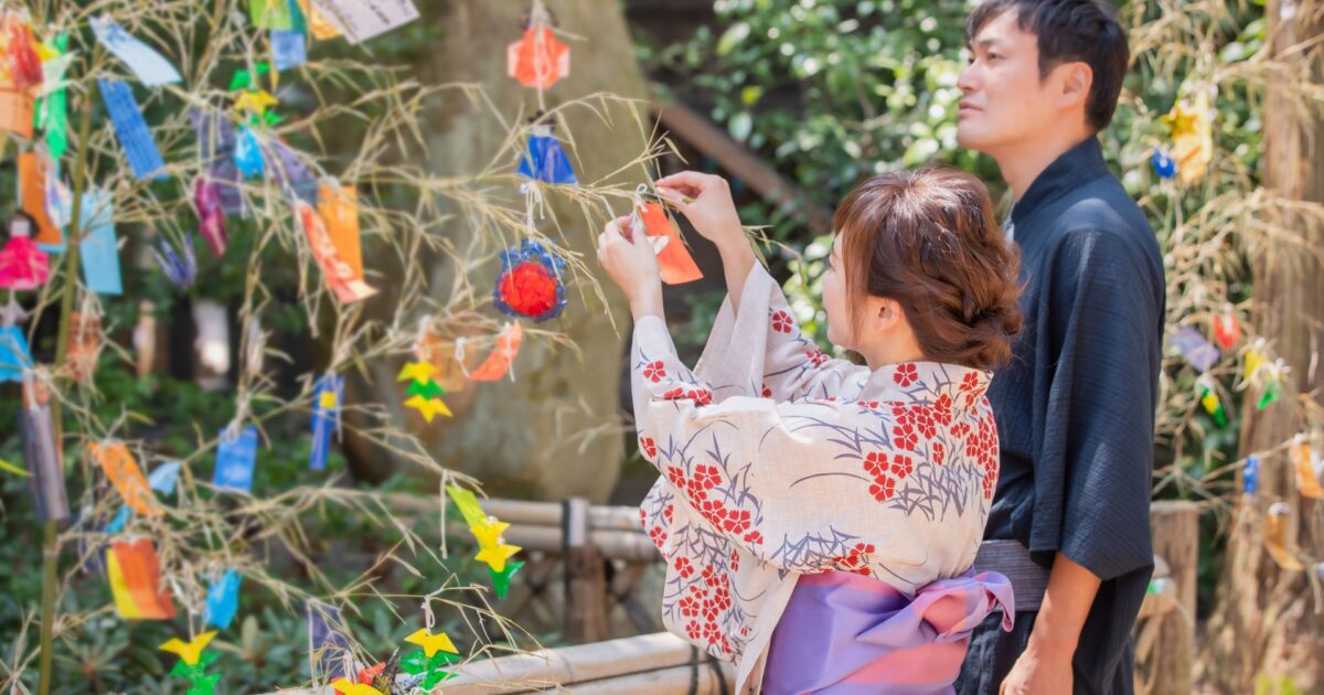 七夕飾りを楽しむ浴衣姿の男女