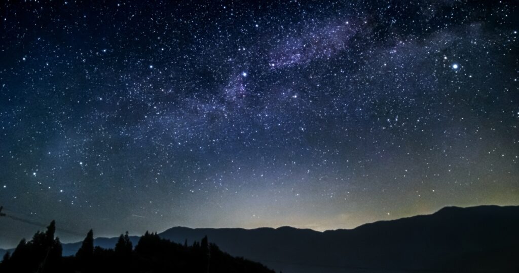 山のシルエットと星空に広がる天の川