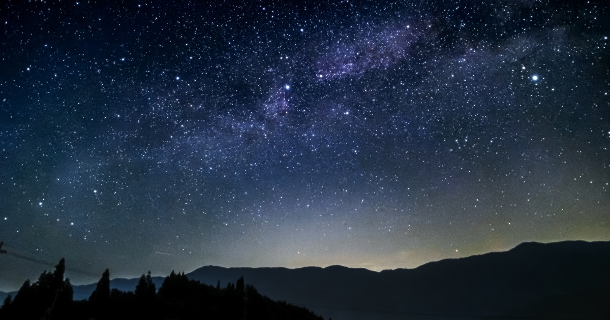 山のシルエットと星空に広がる天の川